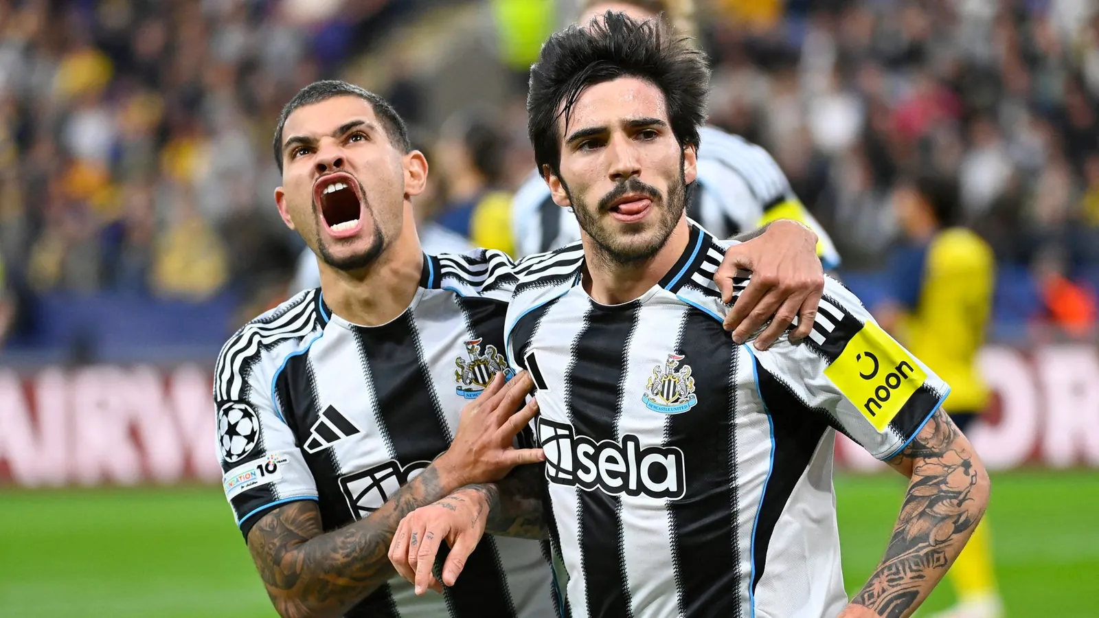 Newcastle United's Italian midfielder #08 Sandro Tonali (R) celebrates scoring his team's first goal with Newcastle United's Brazilian midfielder #39 Bruno Guimaraes during the UEFA Champions League, league phase - Matchday 2 football match between Royale Union Saint-Gilloise and Newcastle United FC at the RSC Anderlecht Stadium in Brussels on October 1, 2025. (Photo by JOHN THYS / AFP)